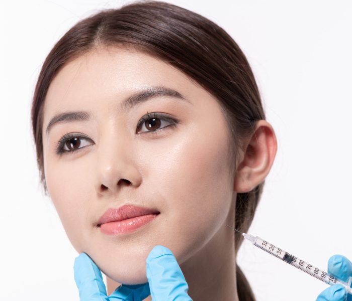 Surgery concept. The doctor cosmetologist makes the Rejuvenating facial injections procedure for tightening and smoothing wrinkles on the face skin of a beautiful.